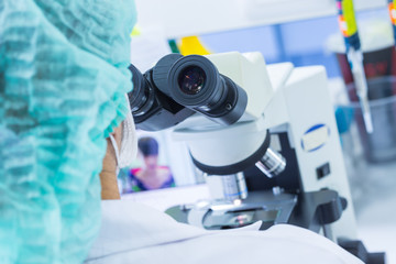 Fototapeta na wymiar Scientist using a microscope in a laboratory