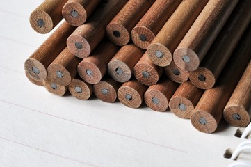 group of pencils on open notebook and show a spiral binder of notebook
