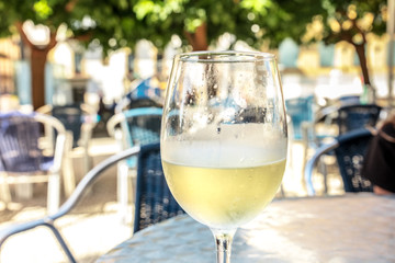 Glass of white wine on terrace, selective focus