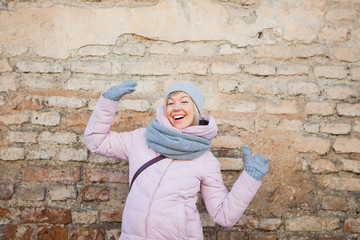 Young adult woman have fun on old brick wall background.