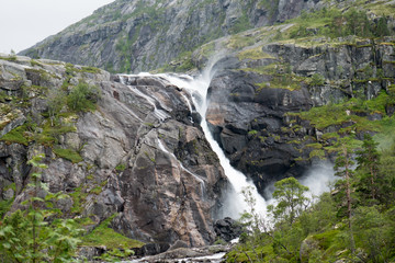 Fototapeta na wymiar Waterfall in mountains of Norway in rainy weather.