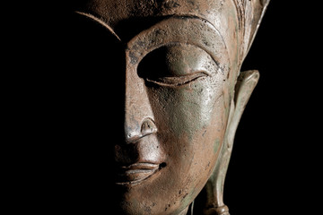 Buddha head. Modern buddhism in focus. Bronze statue face in close up.