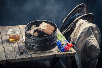 Antique beekeeper tools with honeycombs, hats and honey