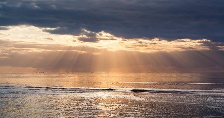 Obraz premium Sunset with clouds and sun rays at the Baltic Bay, Latvia