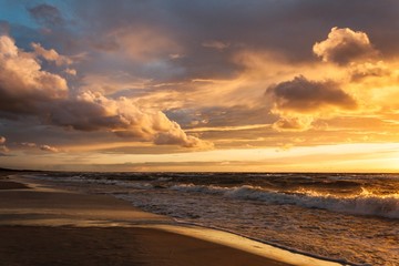 Sunset with clouds and waves at the Baltic Bay, Latvia