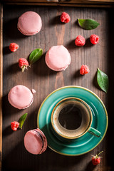 Delicious pink macaroons served with hot coffee