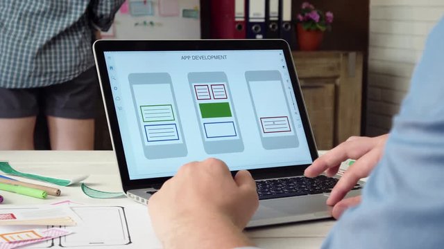 UX designer creating mobile app prototype on his laptop computer