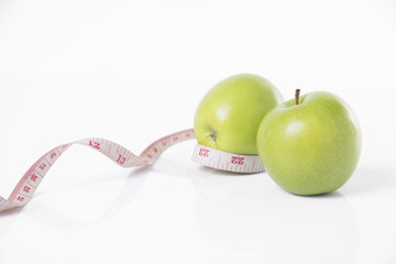 green apple with measure tape on white background. concept nutrition healthy.