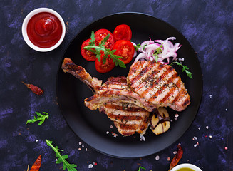 Raw pork steak with herbs on dark background. Raw juicy steak on bone. Top view