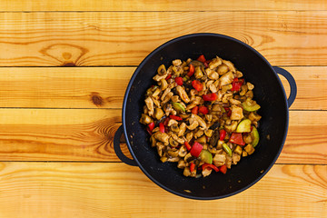 Stir fry chicken, zucchini and pepper in wok