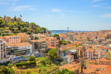 Lisbon aerial view of popular Sao Jorge Castle and Bridge of 25 April from viewpoint Miradouro da Graca. Alfama Quarter in Lisbon, Portugal, Europe. Panoramic view over center of Lisbon in a sunny day
