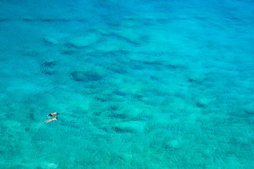 Fototapeta na wymiar Above view of couple snorkeling in turquoise sea water, Glyka Nera, Chania, Crete, Greece