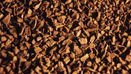 Instant coffee granules scattered brown closeup.