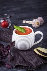 Homemade vegetarian soup puree with eggplant, tomatoes, zucchini and garlic on a dark background