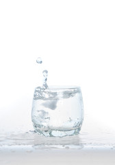 cool water, Ice cubes splashing into glass of water, water splashing from ice cubes being dropped in a glass.