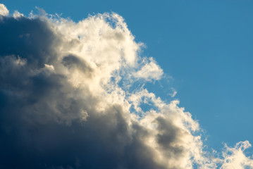 Dramatic sky background with dark black clouds and blue sky, before the storm