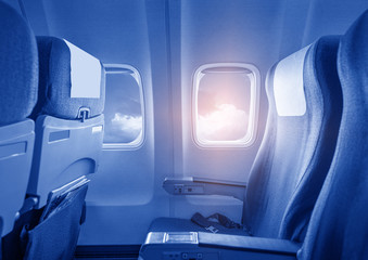 View of the sky and clouds with sunlight from the airplane window,empty seats.