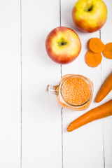 Apple-carrot juice on a wooden table.