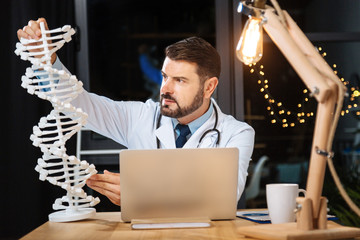 Smart professional researcher studying a DNA model
