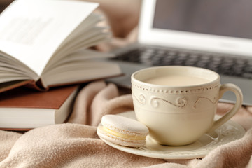 Cup of tea with autumn leaves reflection on book on wooden table. Season of Education