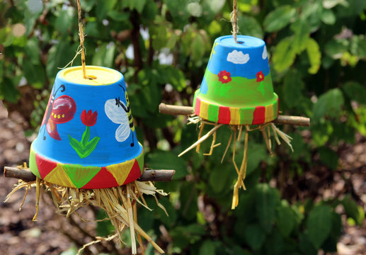 multi colored painted flower pots filled with straw
