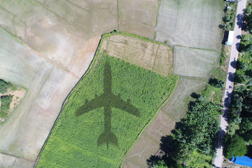 Airplane shadow or Airplane silhouette on landscape village countryside and green filed trees nature and mountain background - Aerial view take a photo by drone camera