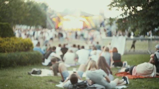 People relax at the festival outdoors. Blurred background