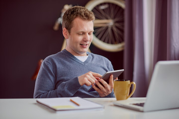 Businessman sitting and using tablet device at home office