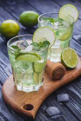 refreshing cold mojito with ice on a black wooden table