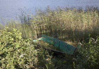 old wooden boat on the edge of the lake