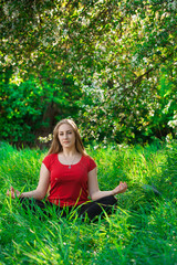 beautiful woman doing yoga outdoors On green grass