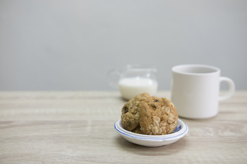 WHITE COFFEE CUP AND COOKIESWhite coffee cup with cookies on the wood table. 