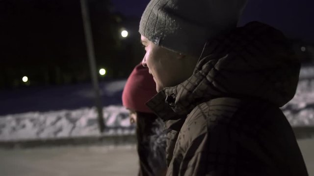 Guy with a girl smiles and rolling on the ice close up