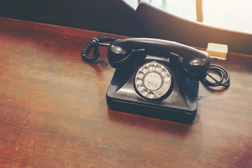Classic old rotary dial telephone on wood table