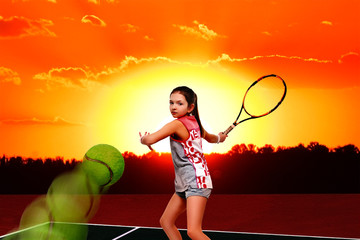 Girl tennis player on the tennis court at sunset