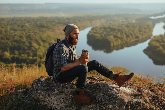 Man with coffee posing in mountains