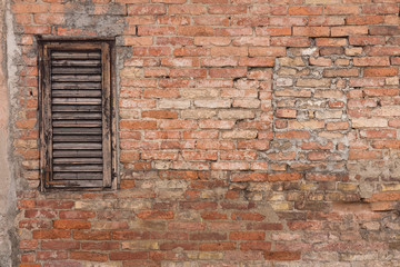 Old and grungy brick wall with old, aged wooden window blinds