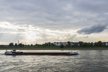 Obraz premium Merchant ship sailing on the Rhine River at dusk in Germany