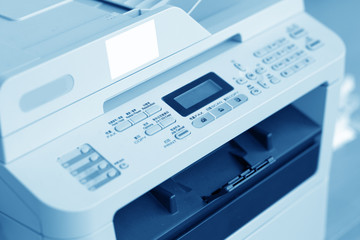 Man holding finger on start button of laser printer