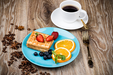 Cup of coffee and pastry on wooden background