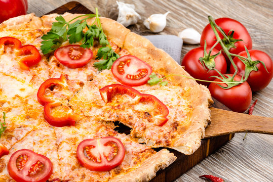Photo of a hot pizza on wooden background
