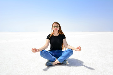 Fototapeta na wymiar Young woman meditate on the salt lake