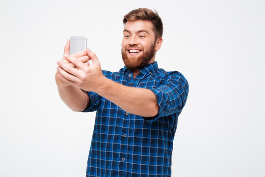 Picture of smiling bearded man in checkered shirt making selfie