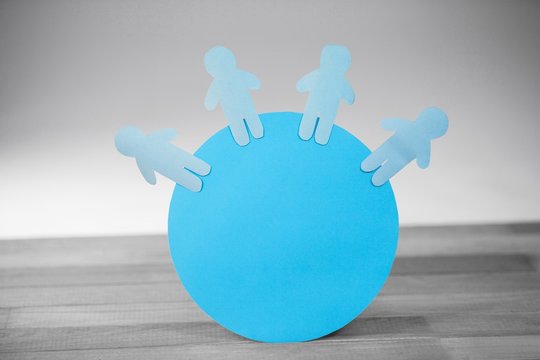 Blue paper cut out figures on globe