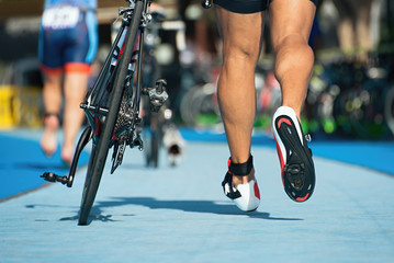 Triathlon bike the transition zone, the triathlonist runs on a bicycle - obrazy, fototapety, plakaty