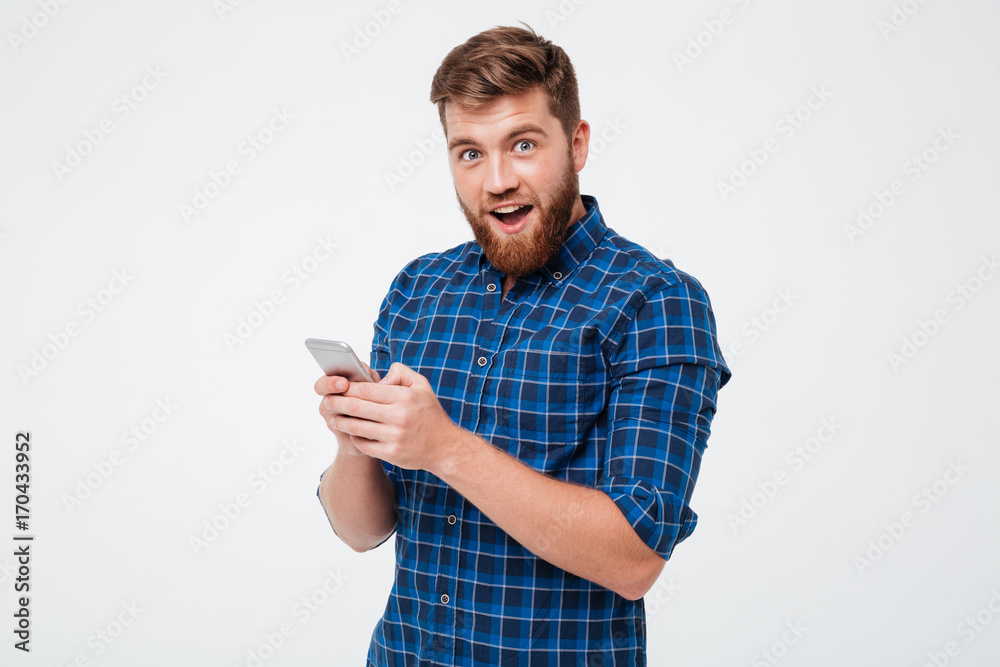 Poster surprised man in checkered shirt using smartphone