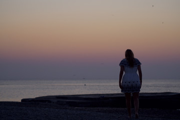 Junge Frau spaziert einsam am Strand 