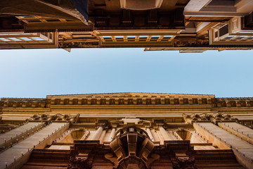 Fototapeta premium Narrow street and high buildings perspective view in Valetta