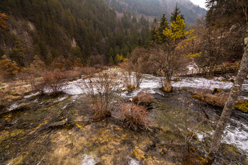 Fototapeta na wymiar Autumn waterfall on a mountainside in the forest