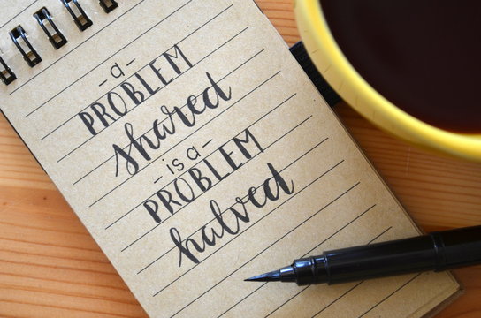 A PROBLEM SHARED IS A PROBLEM HALVED hand lettered in notebook
